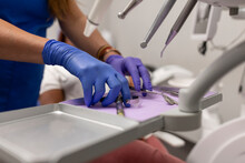 Close Up Of A Female Dentist's Hands Grabbing Some Tools For The Treatment For Her Patient At The Dental Clinic