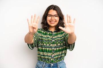 Wall Mural - hispanic pretty woman smiling and looking friendly, showing number nine or ninth with hand forward, counting down