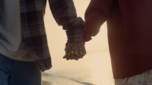 Couple Holding Hands At Sea Beach. Loving Girl And Guy Walking Along Ocean Shore