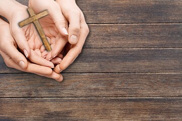 Wall Mural - Human hand holding wooden cross crucifix. Catholicism, Christianity, Thanksgiving, Catholic and Christian faith concept.