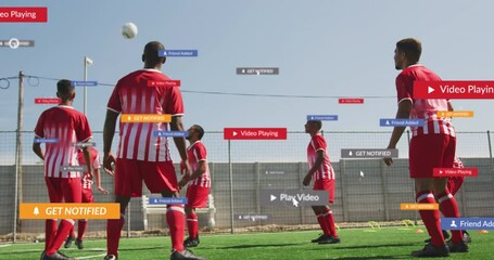 Wall Mural - Animation of social media icons over team of diverse male soccer players practicing on sports field