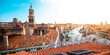 A panoramic view of Venice with red roofs and a turquoise canal.