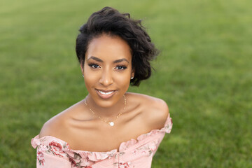 Smiling African-American woman sitting on lawn in a park