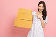 © comzeal - Young Asian woman holding package parcel box isolated on pink background, Delivery courier and shipping service concept