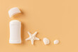 Open solid deodorant antiperspirant, sea star and shells on a pastel orange background. Natural sea mineral toiletries and organic cosmetics for body care concept. Copy space.