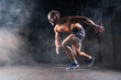 © Monstar Studio - Strong athletic man sprinter ready to run. Professional athlete, runner training on dark background. Muscular, sportive male in dynamic movement. Concept of sport healthy lifestyle, fitness motivation