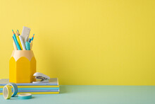 Back To School Concept. Photo Of Stationery On Blue Desktop Stack Of Copybooks Stand For Pencils Mini Stapler And Adhesive Tape On Yellow Wall Background With Copyspace