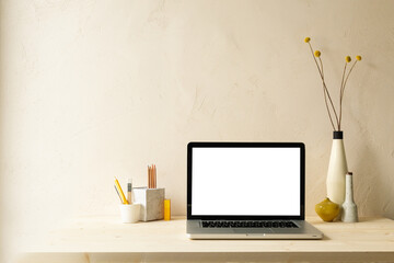 Notebook computer screen, desk objects, office supplies, books on a bright background.
