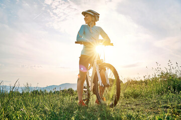 cyclist woman riding bike in helmets go in sports outdoors on sunny day a mountain in the forest. si