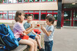 © Elena Medoks - Children sit on a bench in the school yard and eat apples and sandwiches. Snack during break time during class