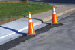 Orange road construction safety traffic cones during road repair construction maintenance work at sidewalk curb city street view photo.