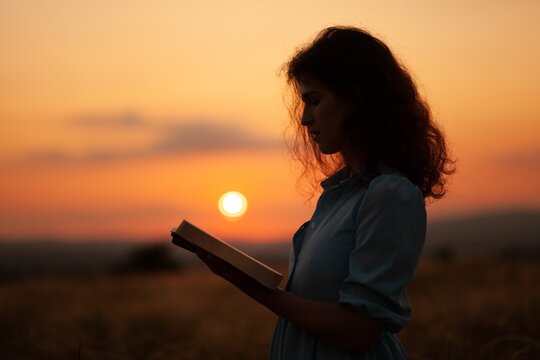 Christian woman holds bible book in her hands.