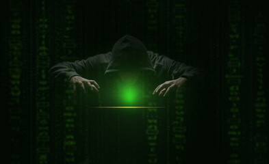 Wall Mural - hacker over a screen with green binary code. crime and information theft and computers