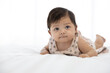 cute baby crawling on bed and drooling from mouth