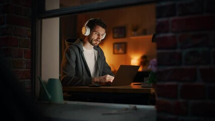 Aufkleber - Professional Software Developer Stretches and Continues Typing on Laptop, Writing Code and Working on the Project. Remote Work at Night Time Concept. View From Outdoors into Window.