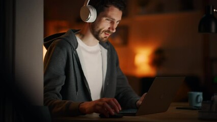 Aufkleber - Information Technology Specialist Working Late on Latptop. Software Engineer Wearing Hoodie, Typing on Computer in His Cozy Home Office Apartment. Remote Work Concept. View From Outdoors into Window.