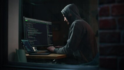 Fototapete - Night Apartment: Evil Greedy Hacker Wearing Hoodie Breaks into Data Servers, Does DDOS Attack, Phishing Scheme, Malware, Sends Virus. Cyber Security and Crime Concept. View From Outdoors into Window.
