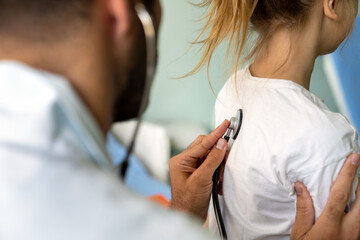 Healthcare medical exam people child concept. Close up of happy girl and doctor with stethoscope