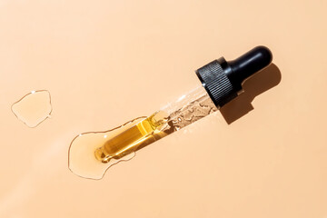 Poster - close up of pipette with pouring liquid serum and shadows on beige background. Trendy cosmetics shot with hard shadows.