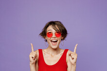 Young Shocked Amazed Happy Woman 20s She Wear Red Tank Shirt Eyeglasses Pointing Index Finger Overhead Indicate On Workspace Area Copy Space Mock Up Isolated On Plain Purple Backround Studio Portrait