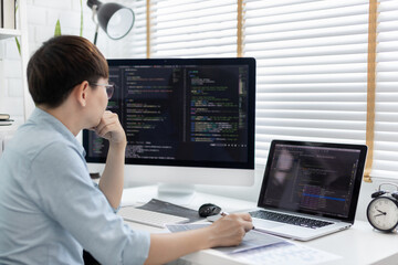 Professional development programmers are laying out a structure or draft on paper in preparation for coding on a computer, Write information or code for the website,  HTML, javascript, Software.