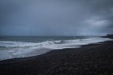 Wall Mural - Sao Vicente, Portugal October, 2021: Black rocky beach at Sao Vicente, on the Northern Coast of Madeira. Dramatic stormy weather.