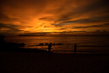Fototapeta Mapy - Couple at the Beach ---   picture of a couple making photos at sunset on a beach in Thailand
