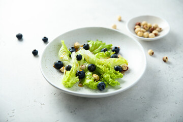 Wall Mural - Green salad with blueberry and hazelnut