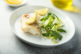 Fototapeta Tulipany - Roasted cod fillet with lemon and salad
