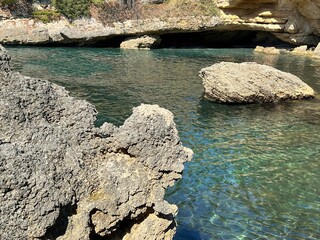 Canvas Print - Scenic rocky coast of the sea. Cliff against clear turquoise sea water in paradise lagoon.