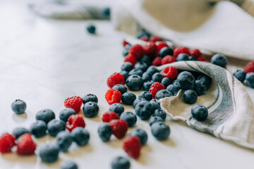 Wall Mural - Background of juicy close-up blurred raspberries and blueberries.