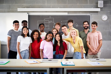 Portrait of a group of students in class looking at the camera. Young people of different ethnicities posing for a photo in the classroom in front of the blackboard. Back to school.