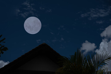 Wall Mural - full moon with roof house silhouette and clouds in the dark night.