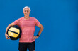 © ADDICTIVE STOCK - Athletic senior man with weight ball in hand smiling at camera