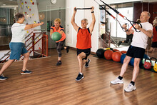Happy Elderly Sportspeople Exercising Together In Modern Fitness Studio