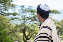 Jewish Man Looking At A Landscape Dressed In Tallit And Kippah Seen From The Back.