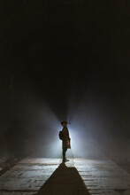 Anonymous Man Exploring Underground Tunnel