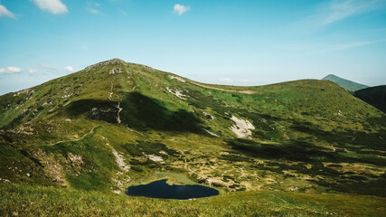 Wall Mural - lake nesamovite and surrounding landscape against background of green mountains and blue sky