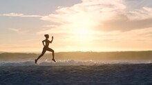 Active, Fit And Sporty Athlete Running On Beach Shore With Waves, Sunset Background And Copy Space. Shadow, Outline And Silhouette Of A Healthy Woman With Stamina Doing Workout, Exercise And Training