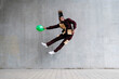 © VISTA by Westend61 - Playful man with balloon jumping in front of concrete wall