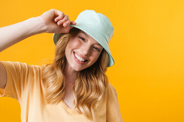 Young blonde woman wearing panama smiling and looking aside