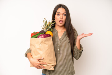 Wall Mural - hispanic pretty woma feeling stressed, anxious or scared, with hands on head. market vegetables bag concept