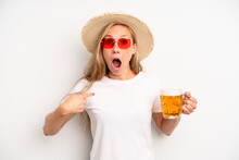 Pretty Caucasian Woman Looking Shocked And Surprised With Mouth Wide Open, Pointing To Self. Beer Pint Concept