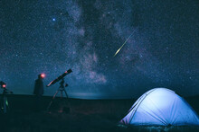 Amateur Astronomer With Astronomical Telescope Camping In Nature Under The Milky Way Stars.