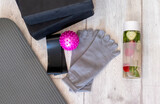 Fototapeta  - Top view of the sports equipment. Yoga blocks, detox water, expander tape, mfr ball and toe socks.
