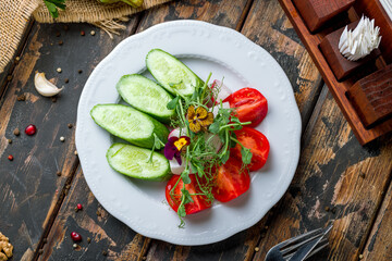 slicing fresh vegetables on a plate top view on old wooden table