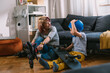 © cherryandbees - mother and son preparing for riding skateboard and rollerblade. they are sitting in living room