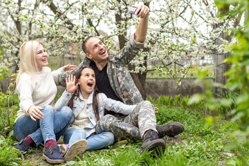 Wall Mural - Soldier reunited with his family in park.