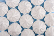 White meringue cookies on blue background top view