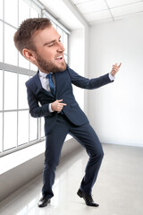 Canvas Print - Funny dancing businessman with big head in office